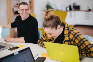 Man and woman laughing in office